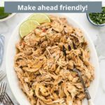 A large serving dish of Mexican shredded chicken with a fork in it surrounded by ingredients and silverware with a graphic overlay.