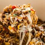 Cheese stringing from a spoonful of Mexican stuffed pepper casserole.
