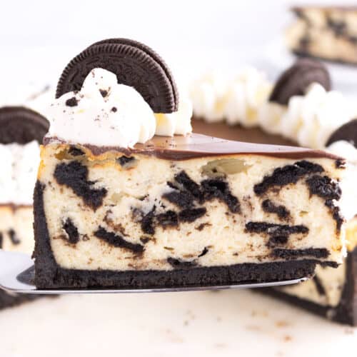 A serving tool holding a slice of oreo cheesecake.