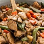 A wooden spoon scooping up a serving of teriyaki stir fry.
