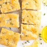 Focaccia bread squares clustered together topped with salt and herbs.