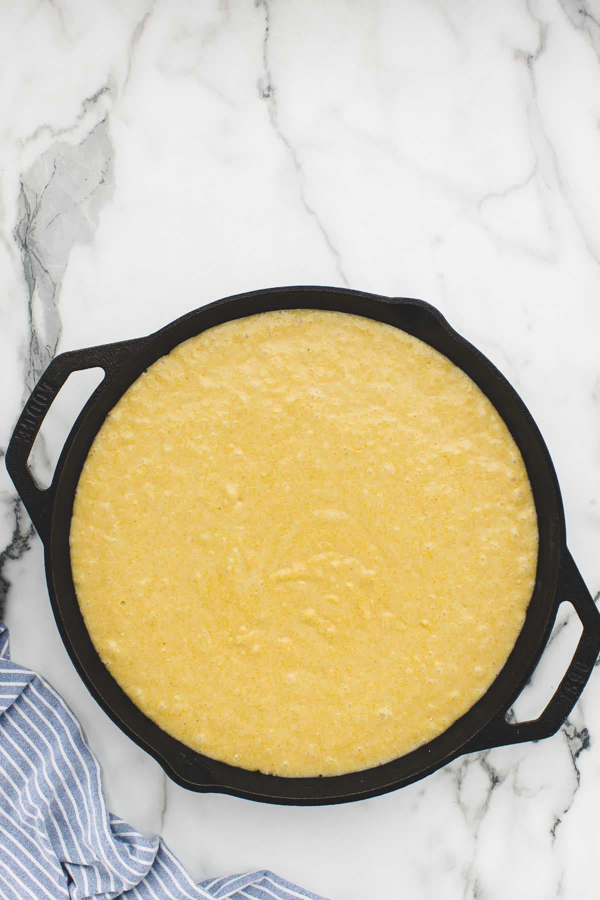 Cornbread batter in a cast iron skillet.