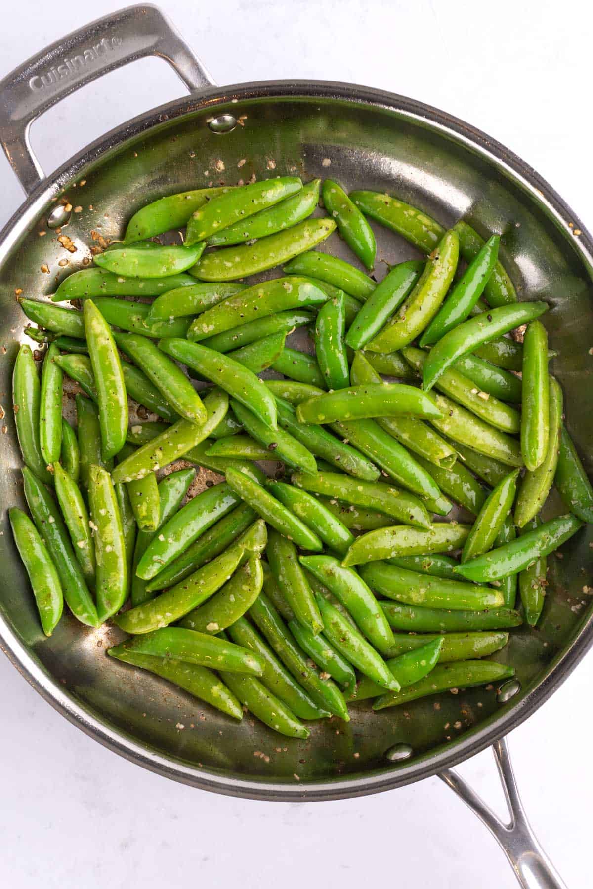 A skillet of seasoned snap peas.