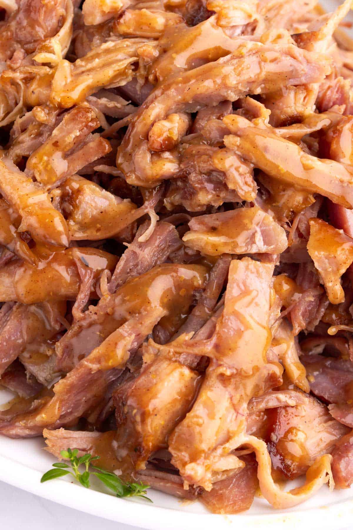 Shredded ham on a serving platter drizzled with rum glaze.