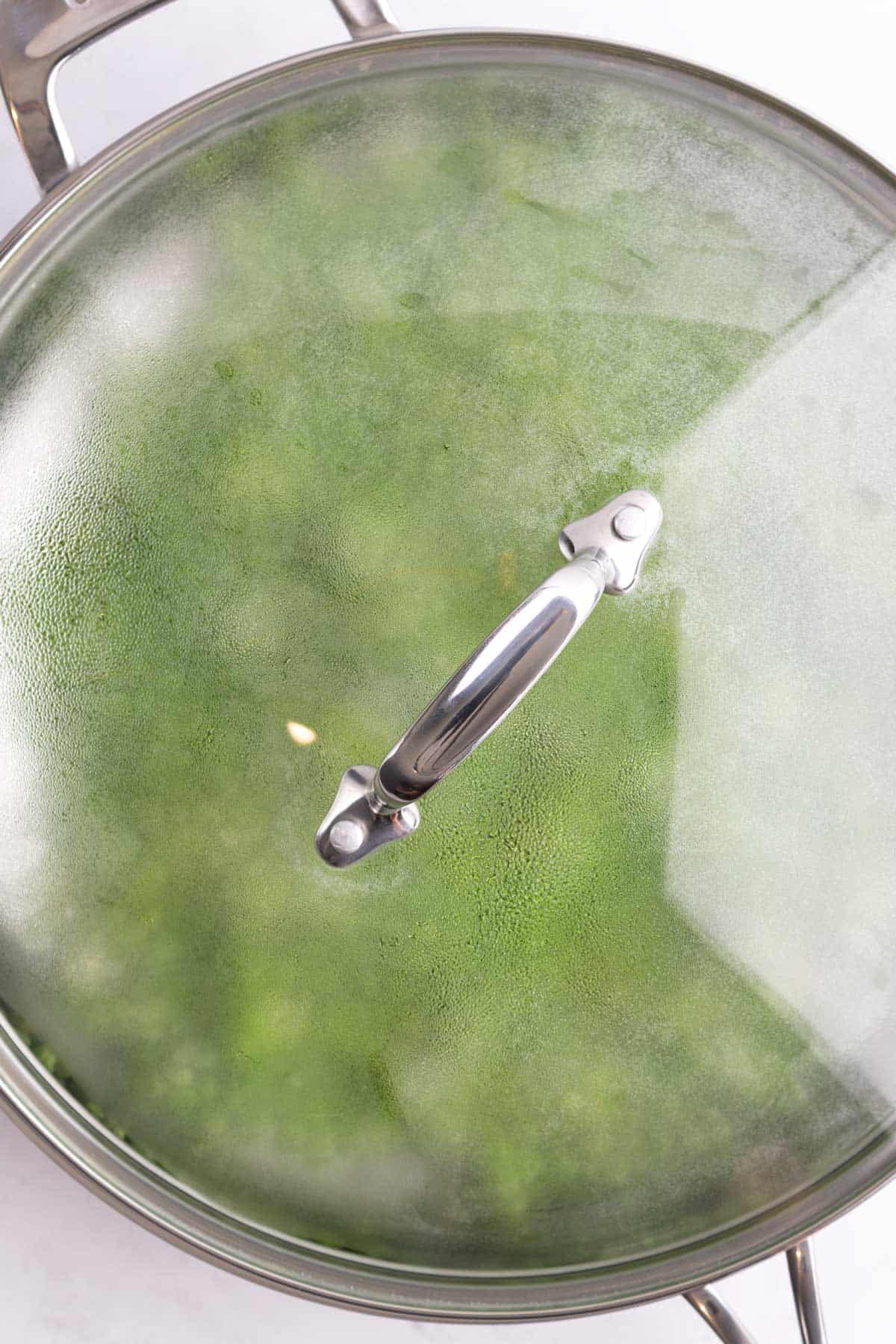 A cooking pan of peas covered with a lid.