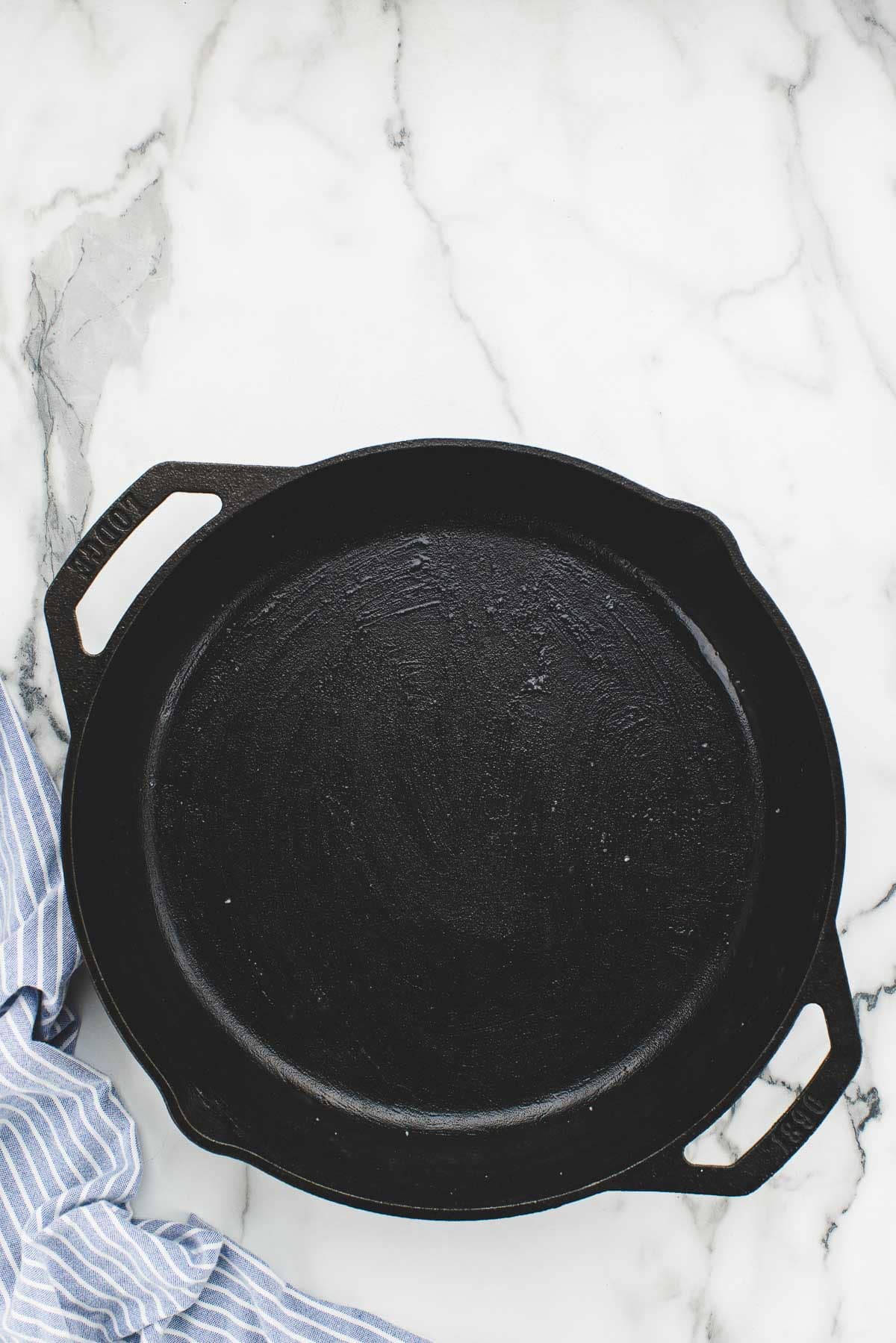A cast iron skillet on a marble counter.