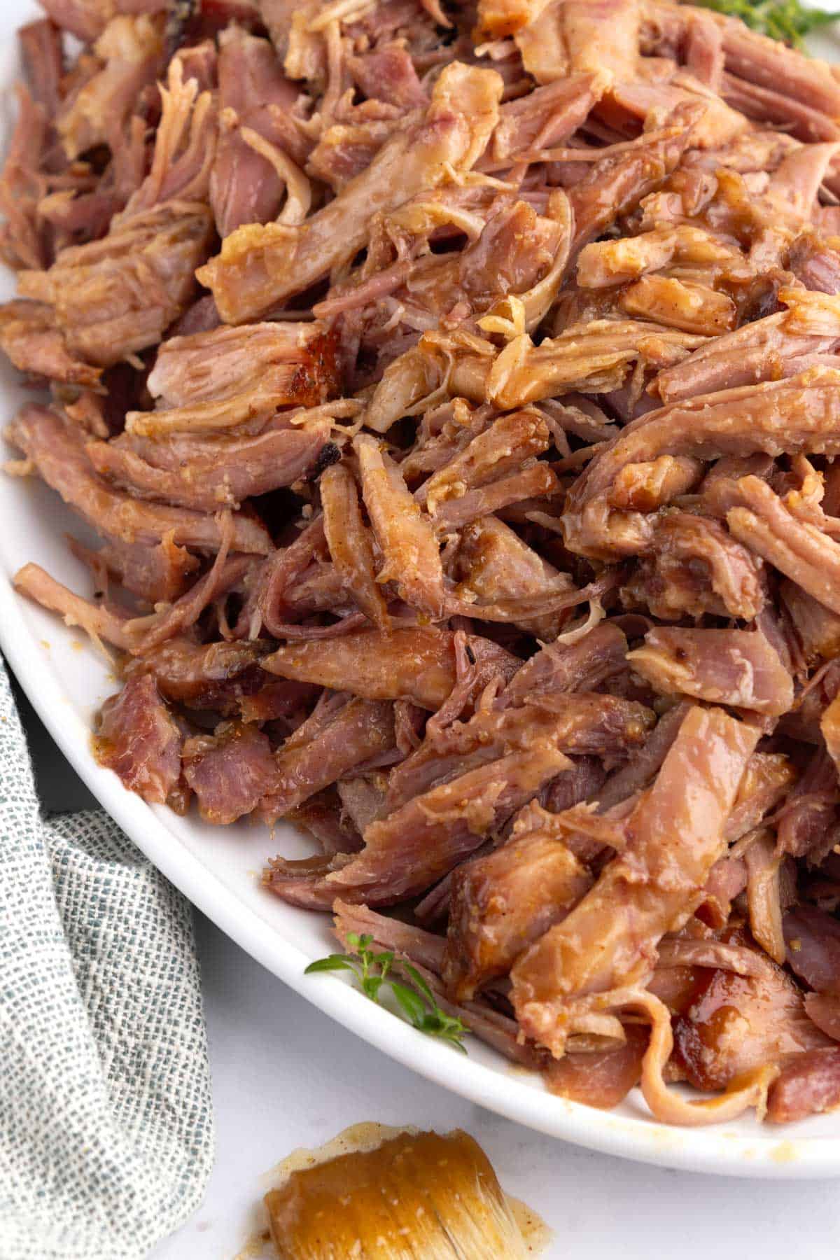 A large platter of shredded smoked ham with homemade glaze.