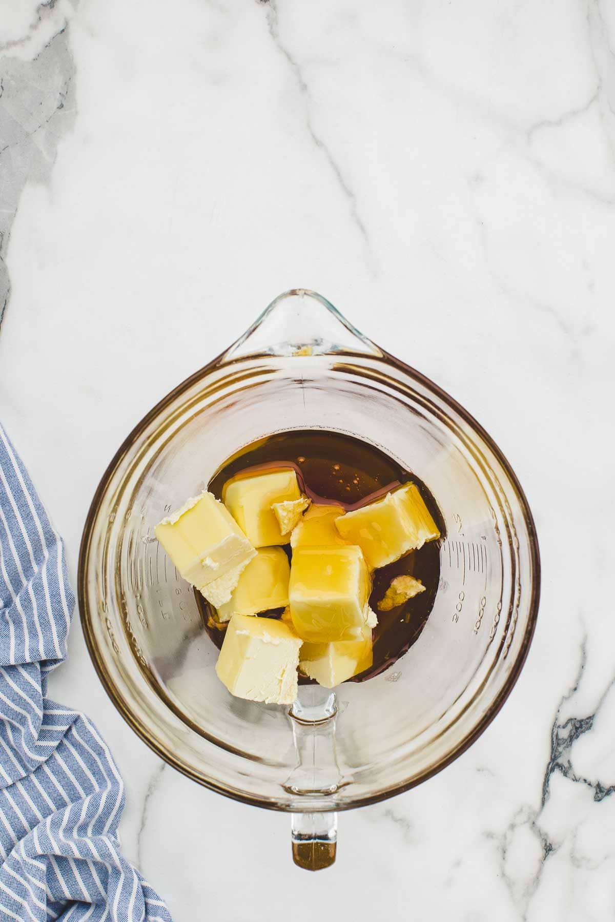 Cubes of butter added to a dish of hot honey.