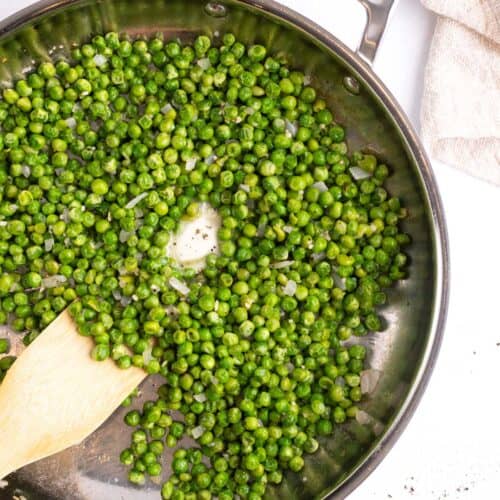 Sauteing peas in a skillet with butter.