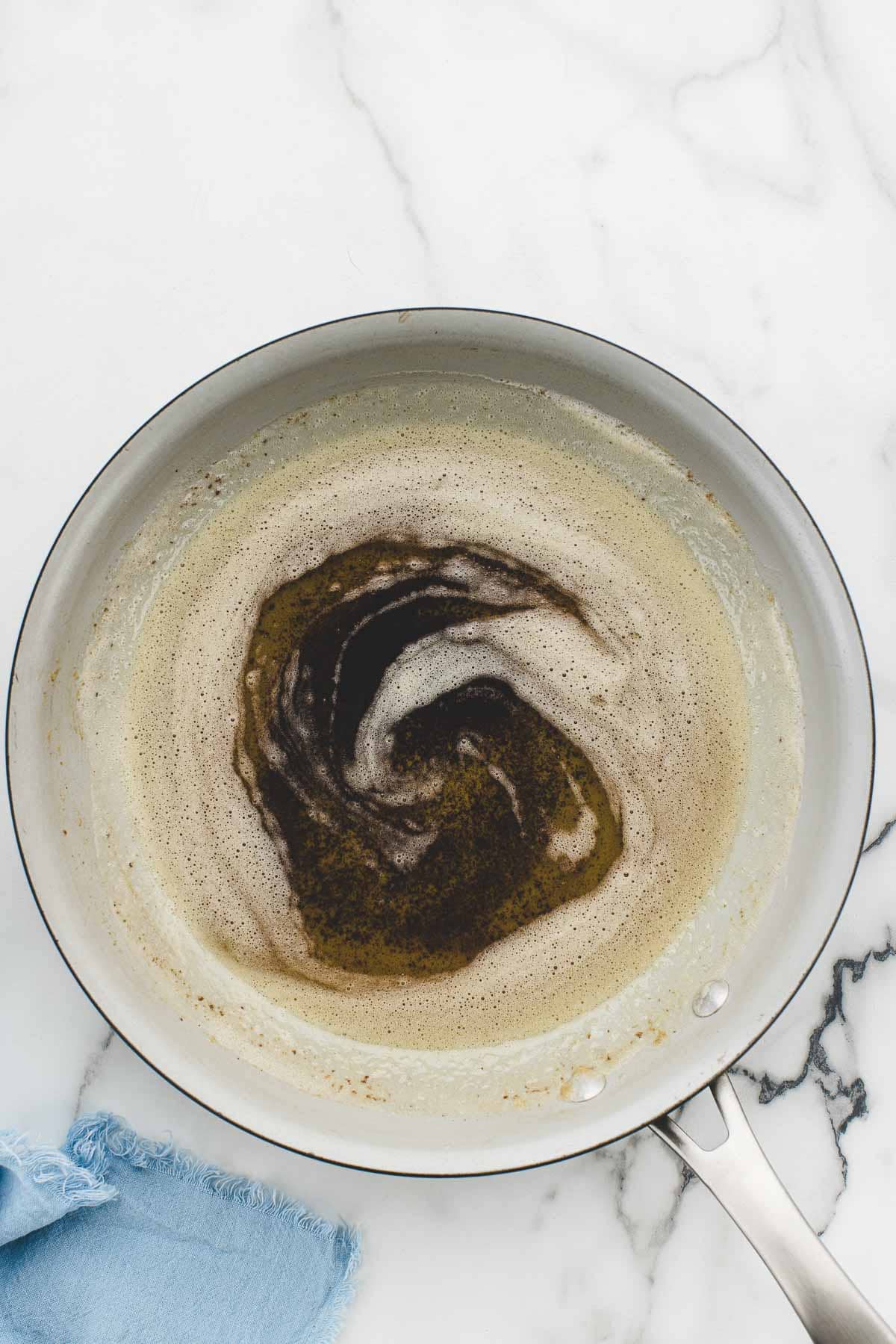 Foaming brown butter in a saucepan.