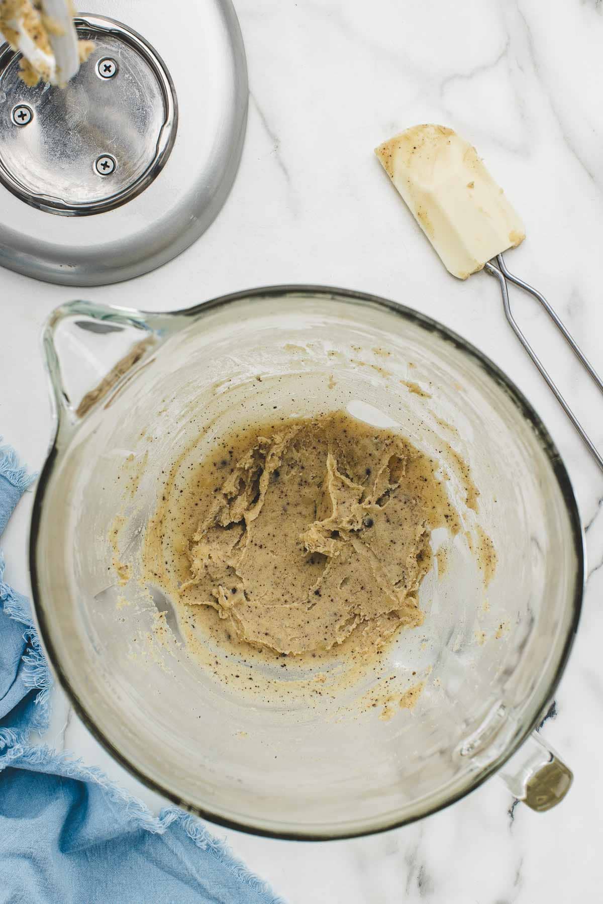 Frosting ingredients mixed in a bowl with a rubber spatula.