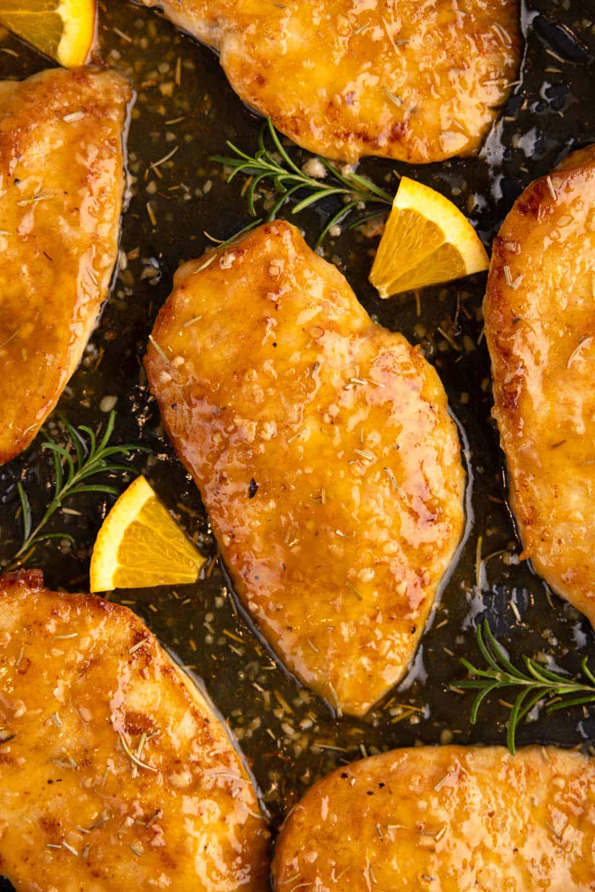 Closeup of chicken breasts cooking in a skillet.