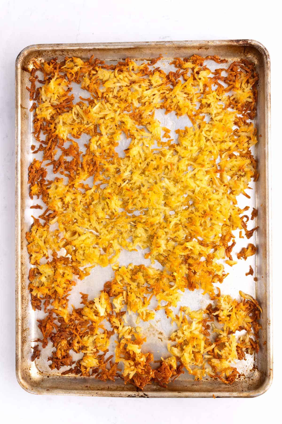 A sheet pan full of crispy hash browns.