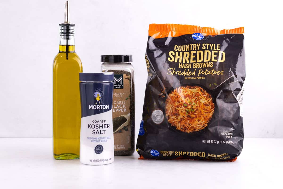 Frozen potatoes, salt, black pepper, and oil on a countertop.