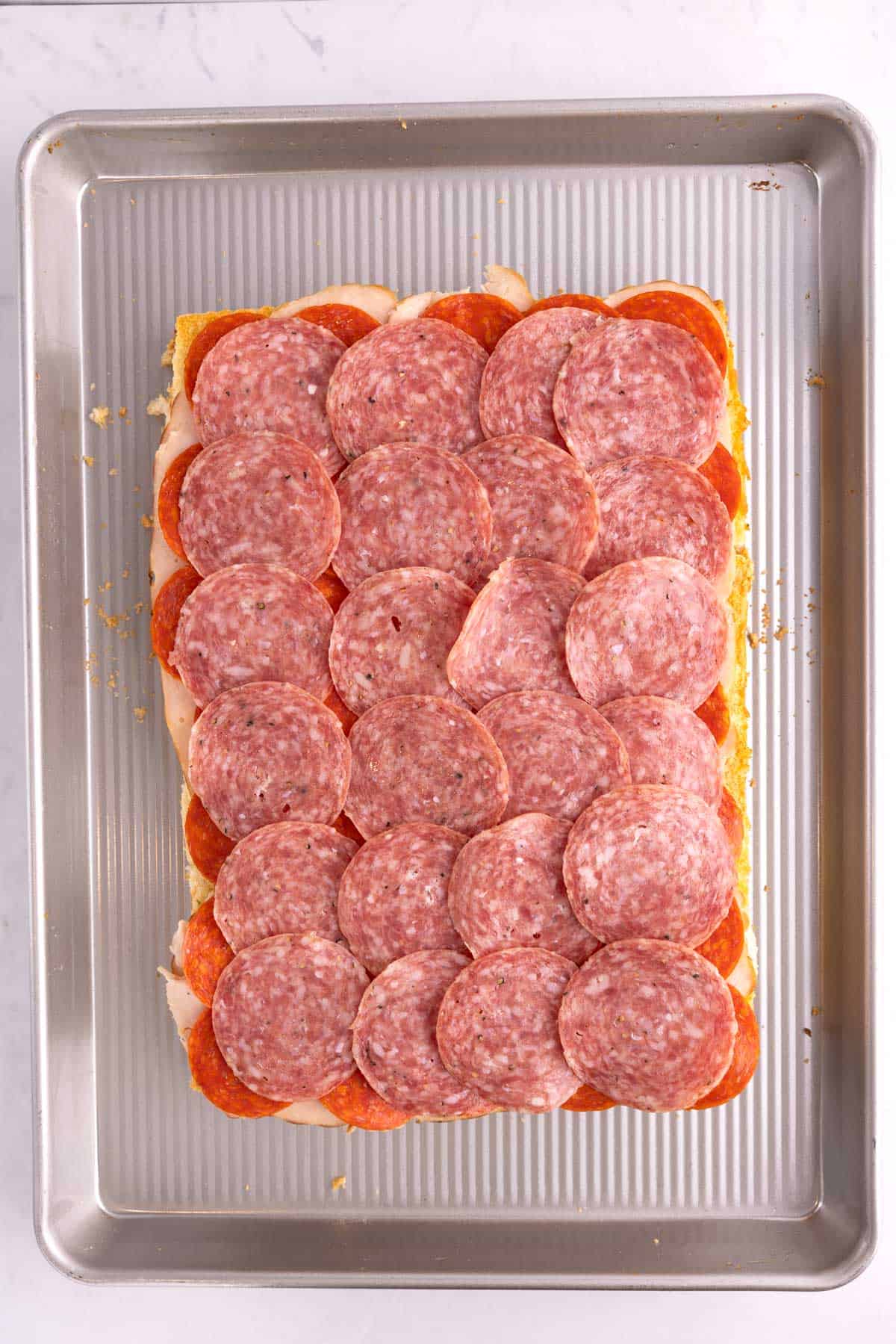 Rows of meat piled onto slider buns.