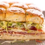 Italian sliders on a large sheet pan sprinkled with seasonings.