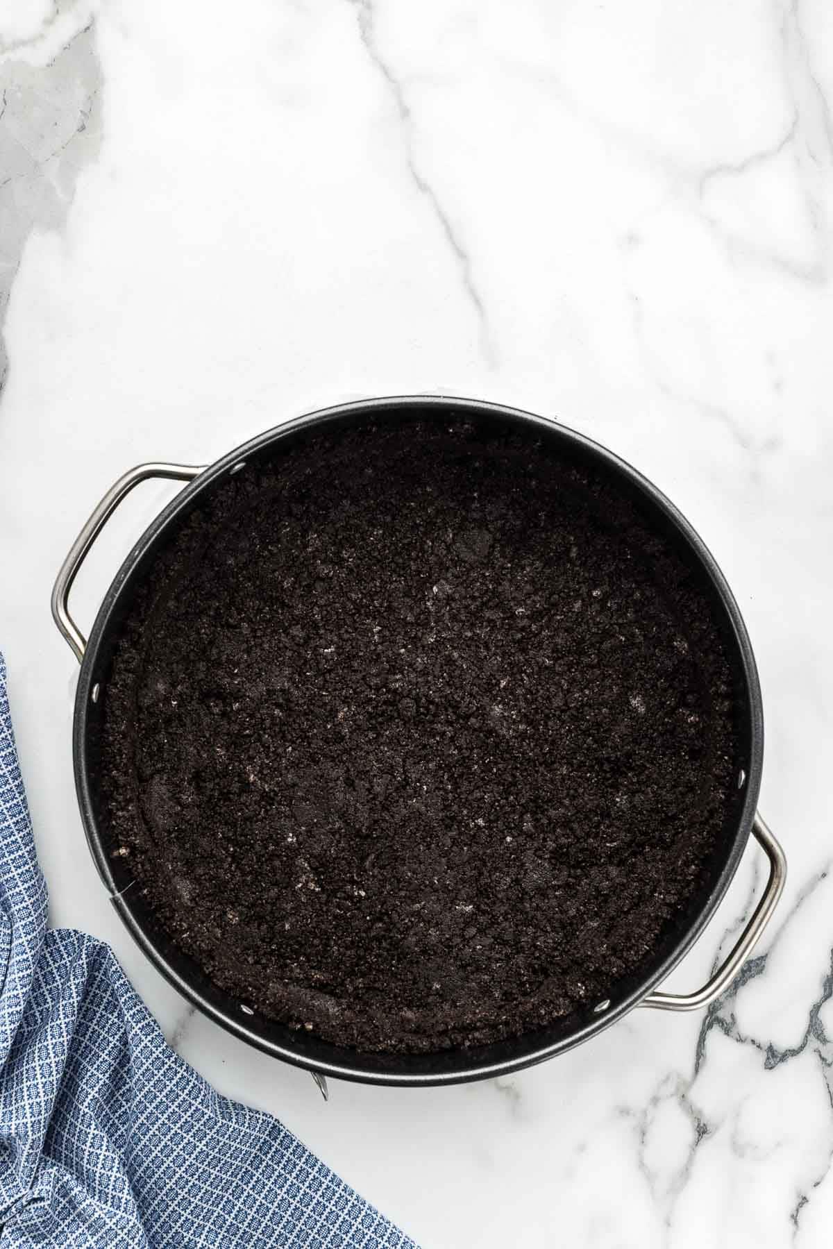 Oreo crust in a round pan.
