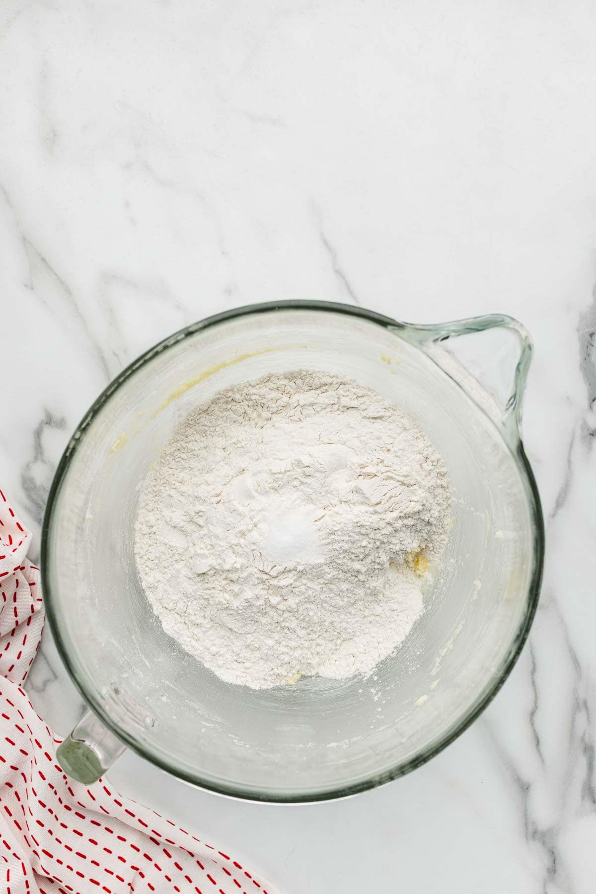 Dry ingredients unmixed in a glass measuring cup.