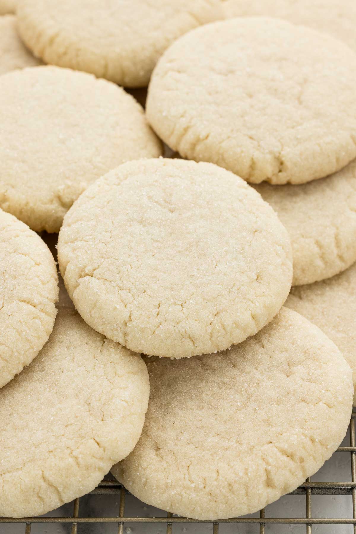 Cookies piled on top of each other on a cooling rack.