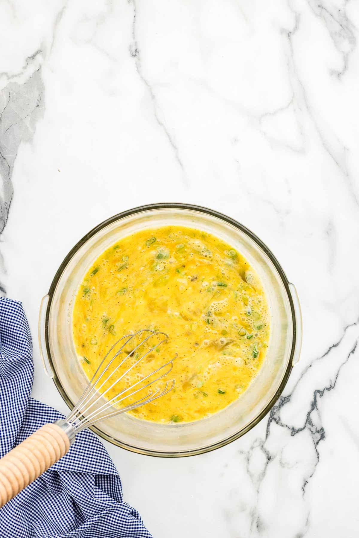 Mixed ingredients in a mixing dish with a whisk.