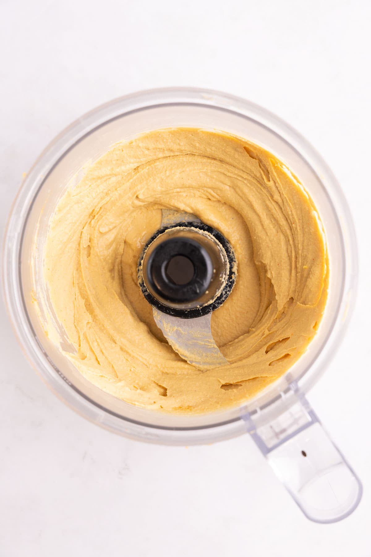 Blended hot honey hummus in a food processor.