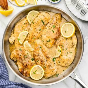 Cooked lemon chicken with creamy sauce in a large skillet.