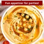 A bowl of hot honey hummus topped with honey and chickpeas with a graphic overlay of text.