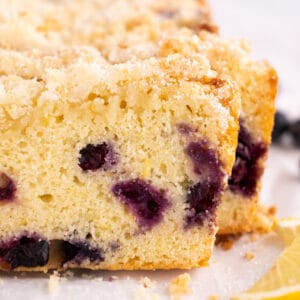 Slices of lemon blueberry bread with lemon slices next to them.