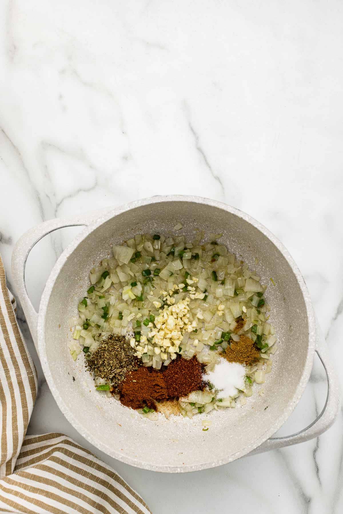 A large white pot with piles of unmixed ingredients.