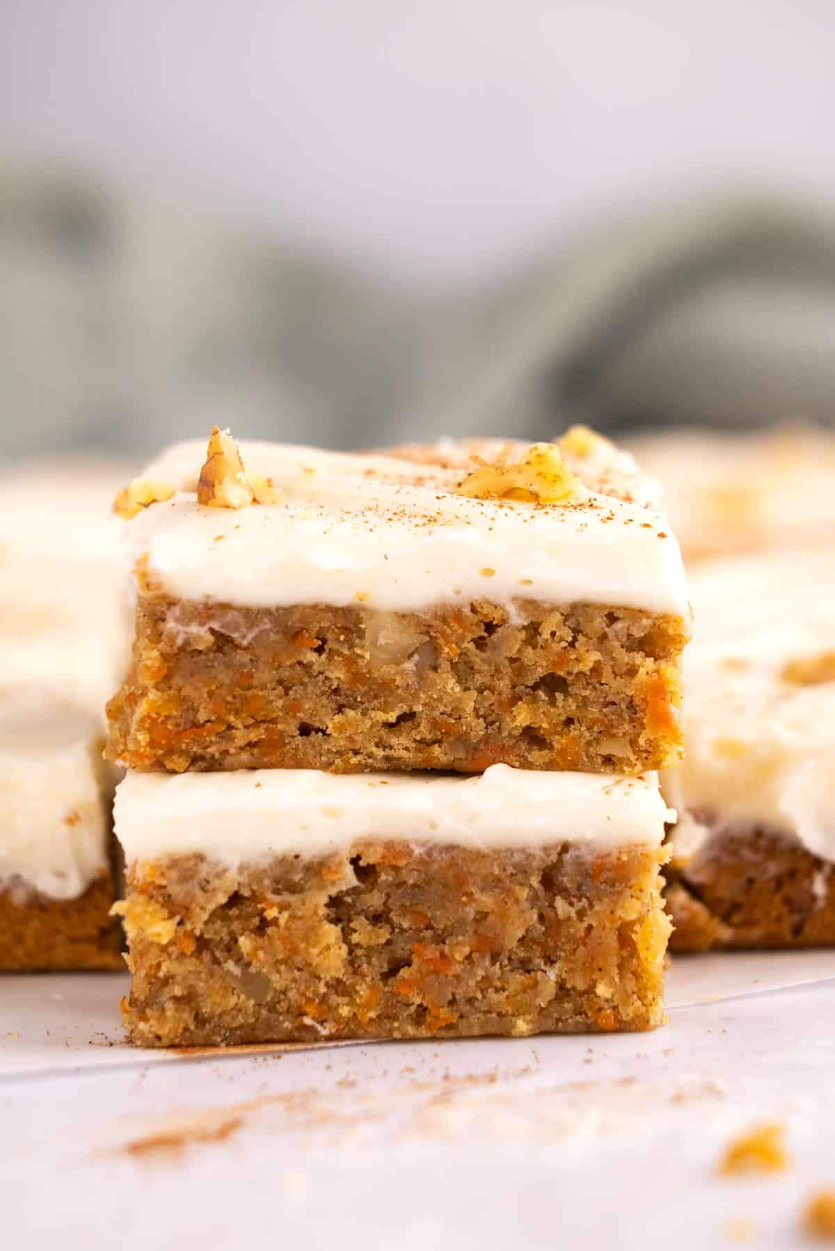 Two bars of carrot cake stacked on top of each other.