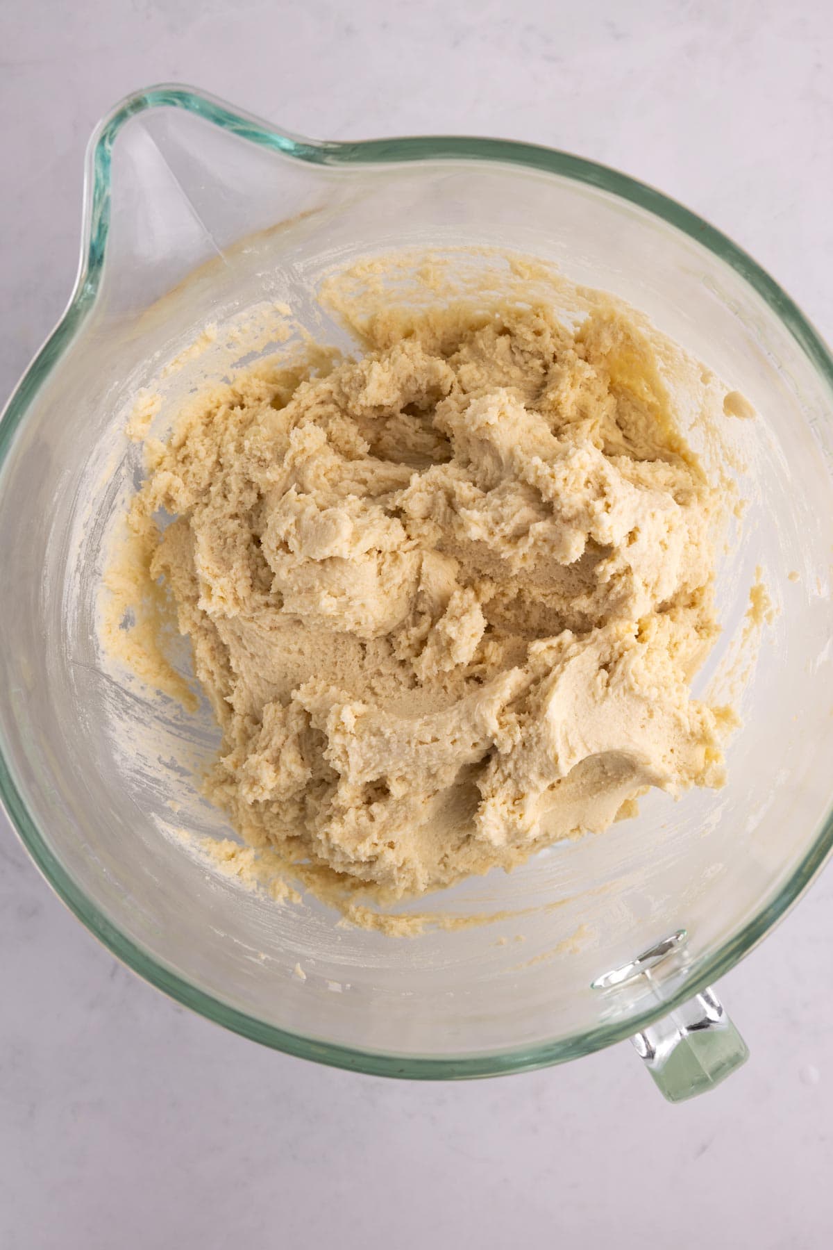 Cookie dough at the bottom of a mixing bowl.