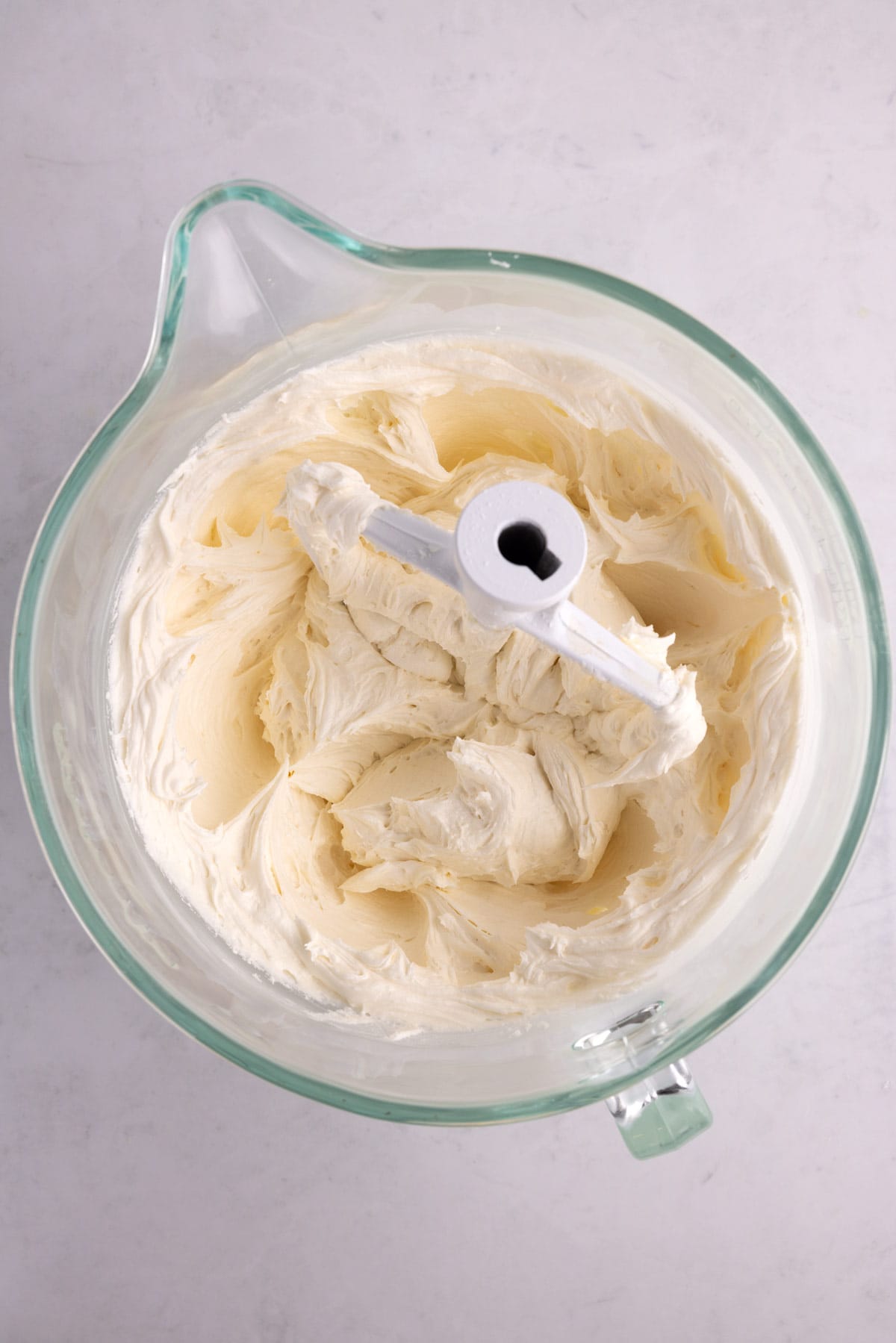 Frosting mixed in a glass pitcher with a paddle.