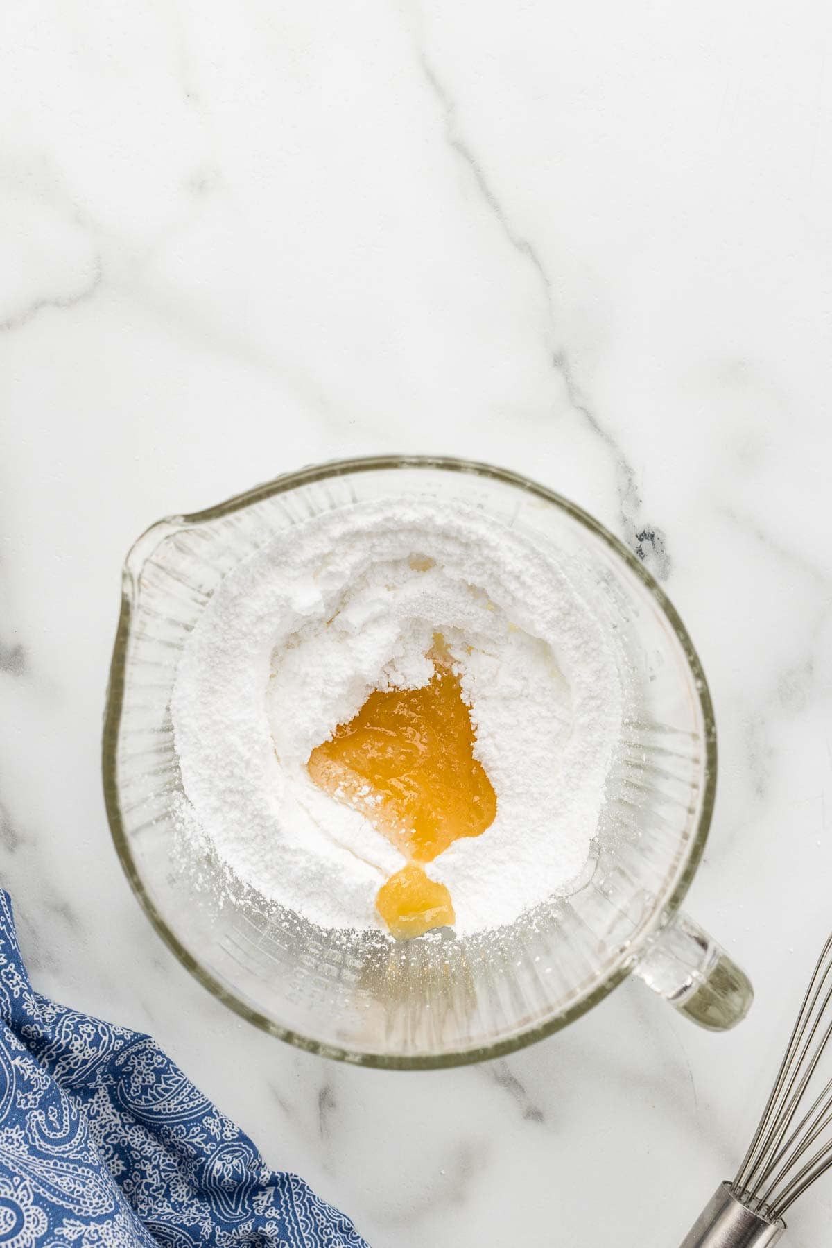 Monkey bread glaze ingredients in a glass measuring cup with a whisk beside it.