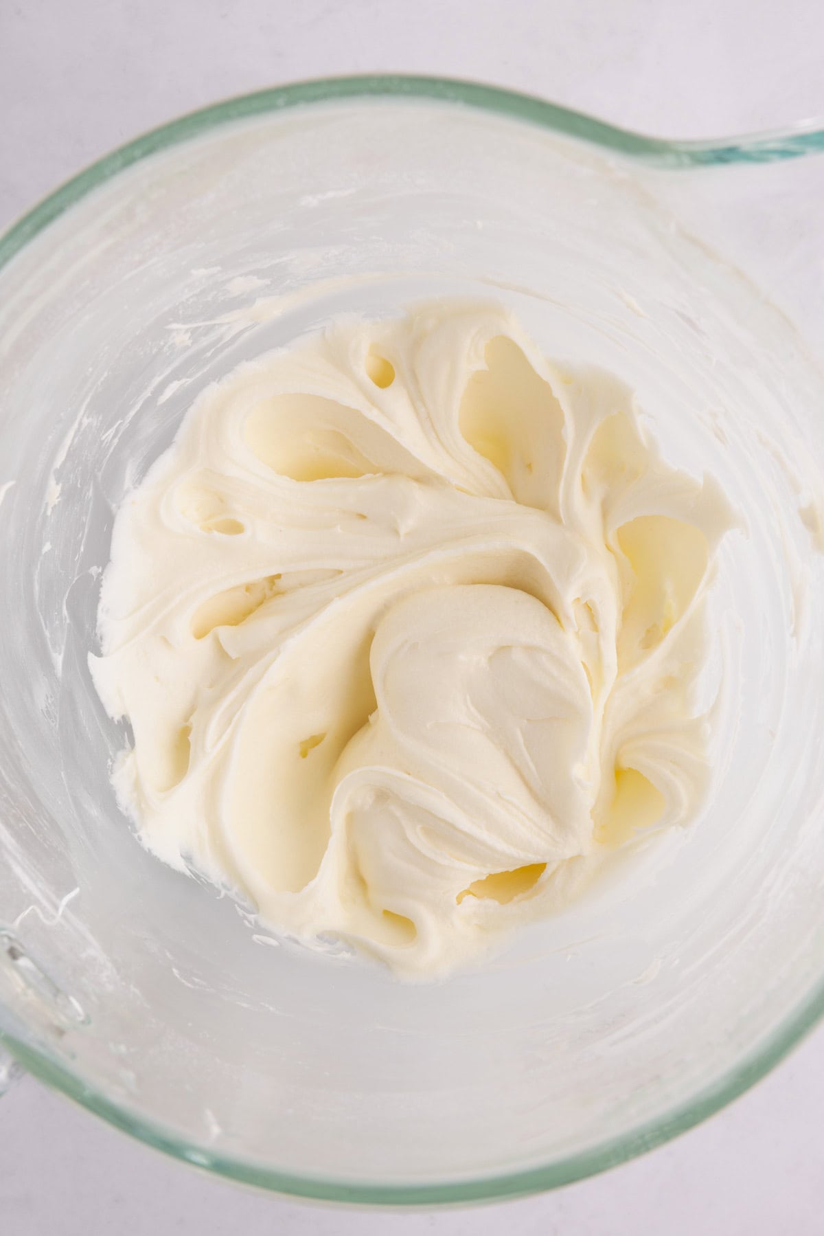 Blended frosting in a measuring cup.