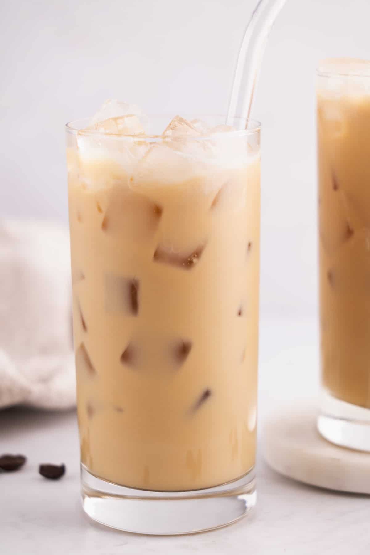 Closeup of a glass of iced coffee with a straw.