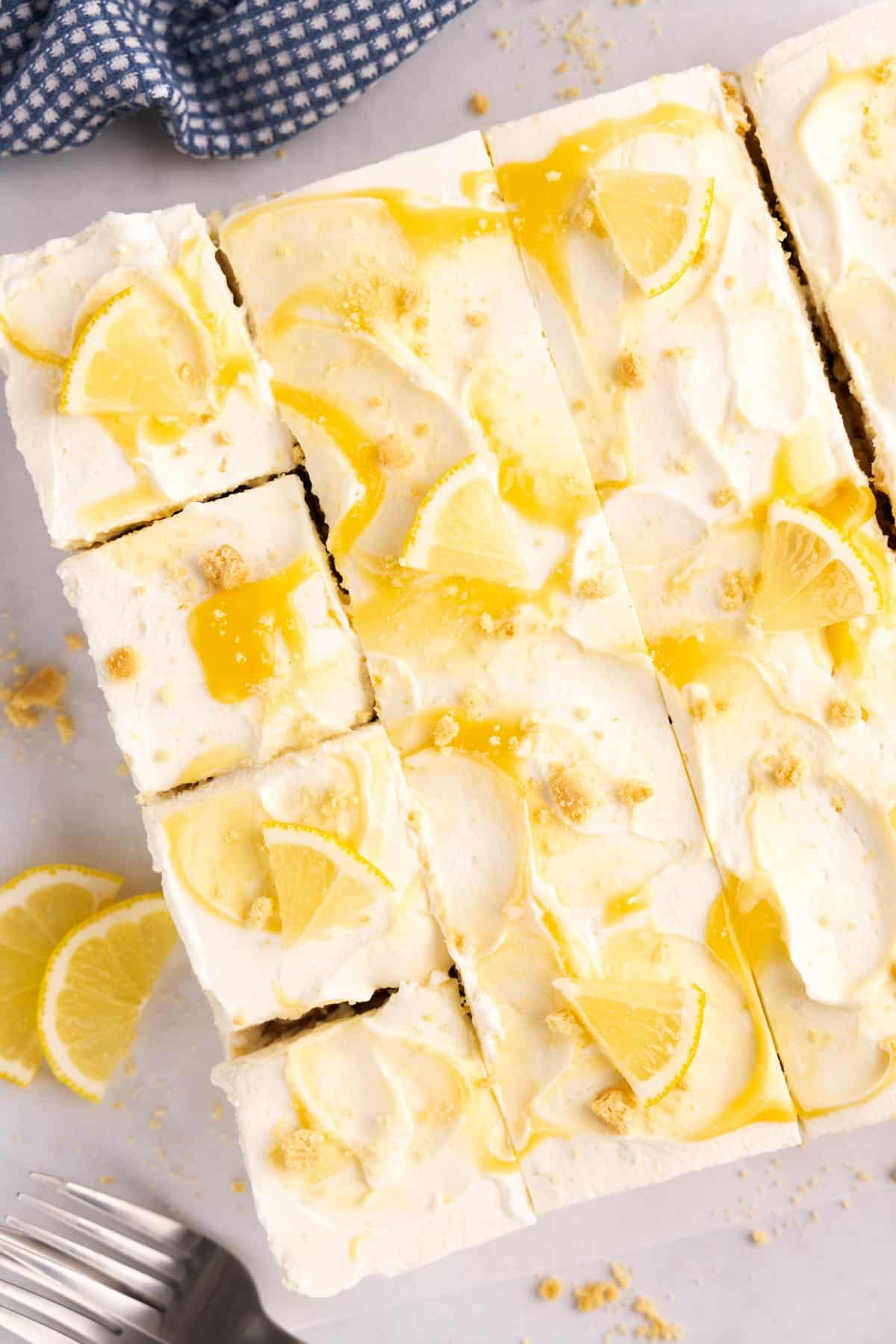 Overhead of a lemon icebox cake sliced into cubes on parchment.
