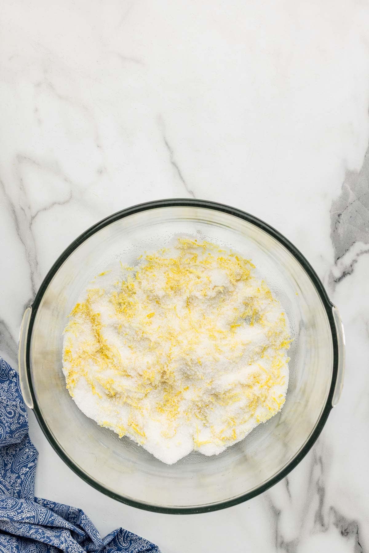Lemon sugar mixture in a glass mixing bowl.