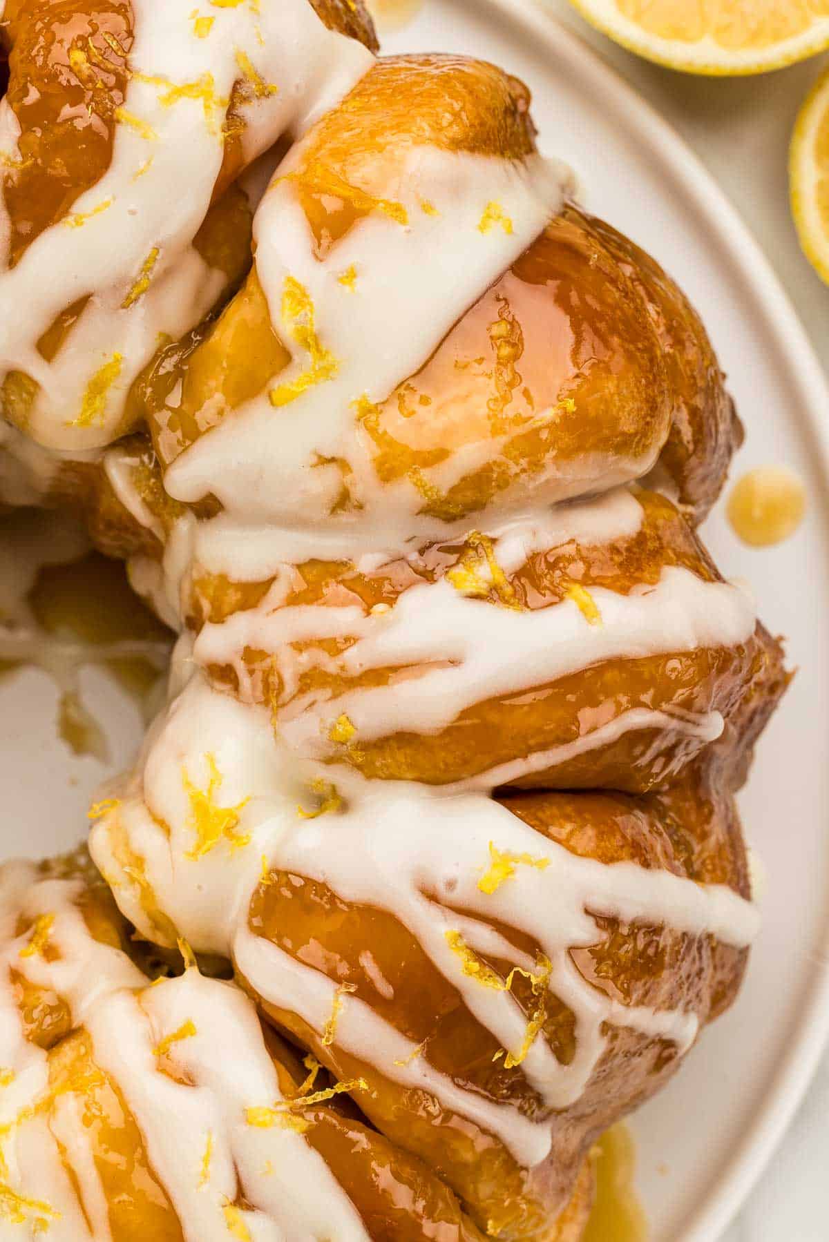 Closeup of lemon monkey bread with glaze dripping down the side.