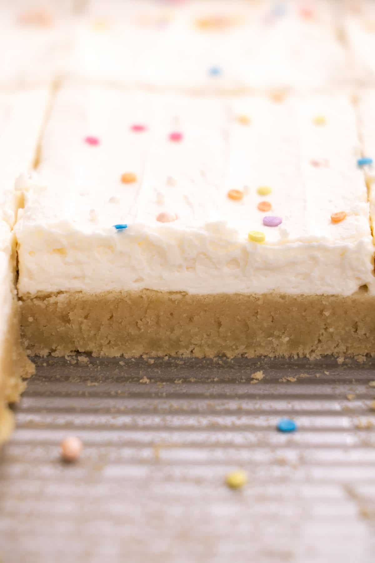 Upclose of the side of a sugar cookie bar in a sheet pan.