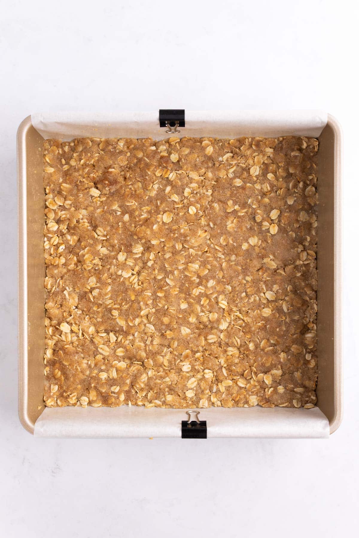 Oat crust pressed into the bottom of a baking pan.
