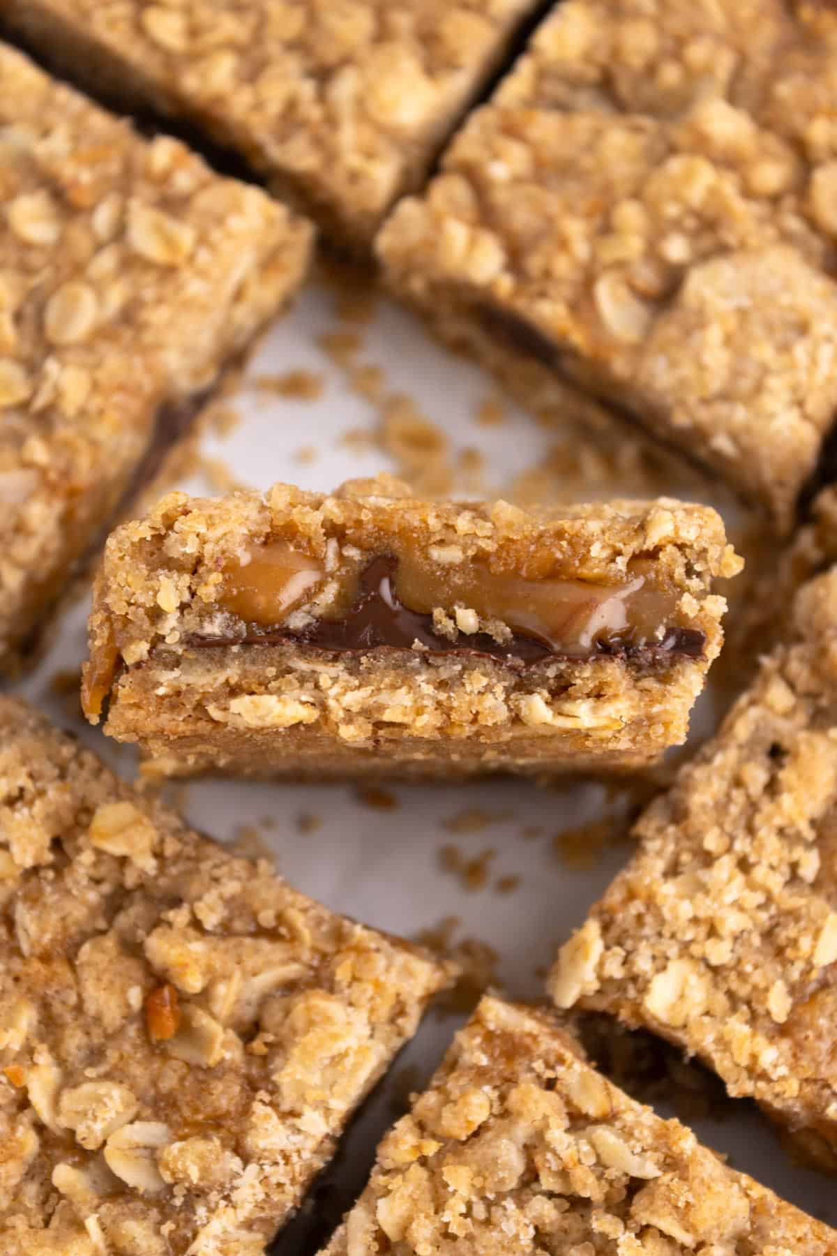 Closeup of a caramelita bar standing upright with more bars surrounding it.