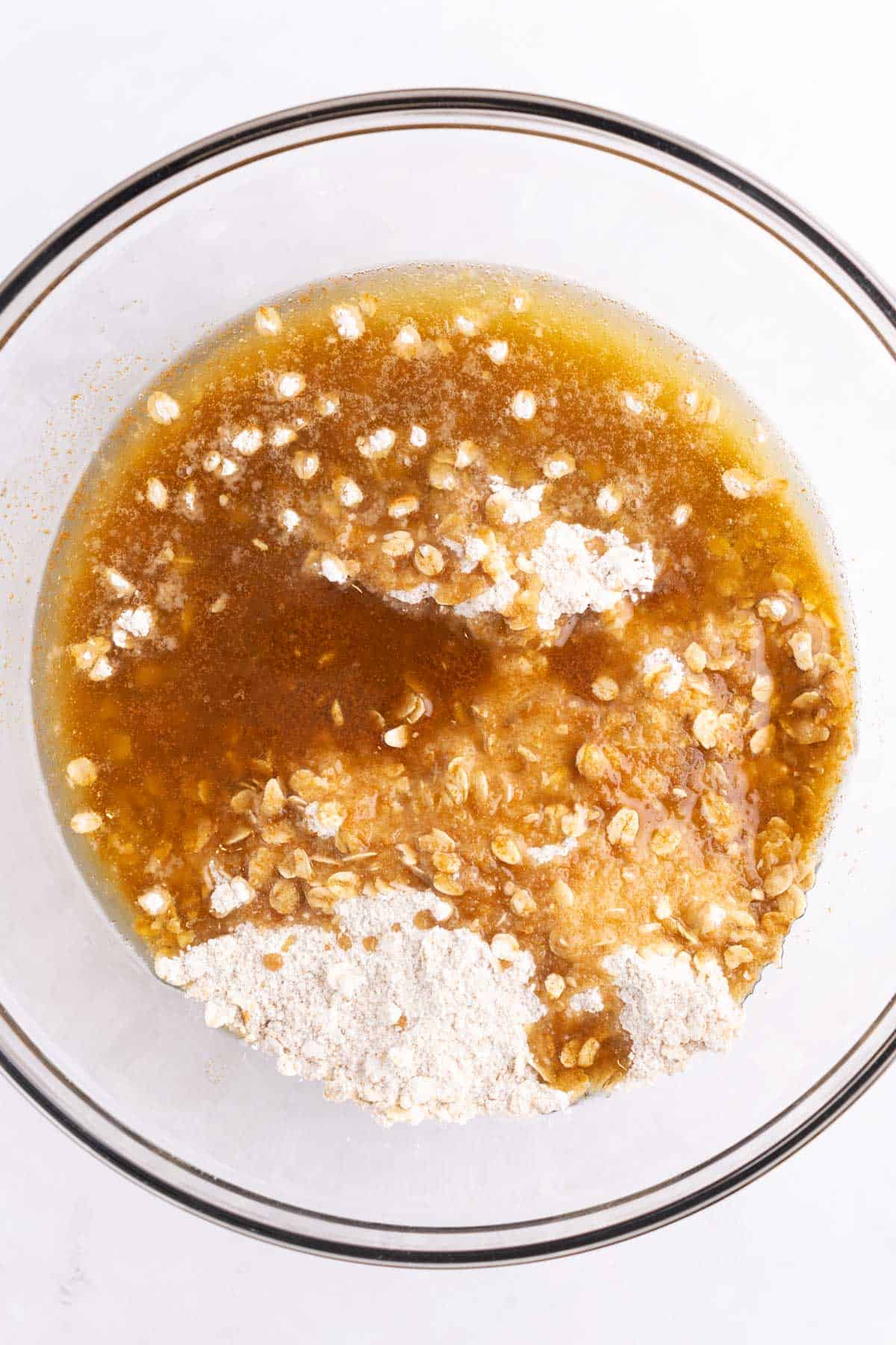 Dry and wet ingredients combined in a glass mixing bowl.