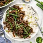 Asian ground beef over rice in a serving dish with a fork.