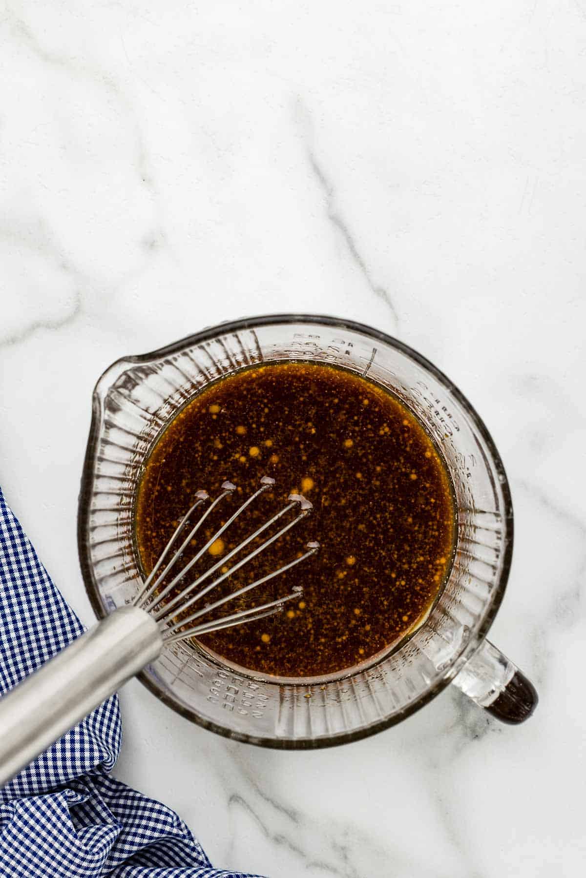 Sauce in a mixing glass with a whisk.