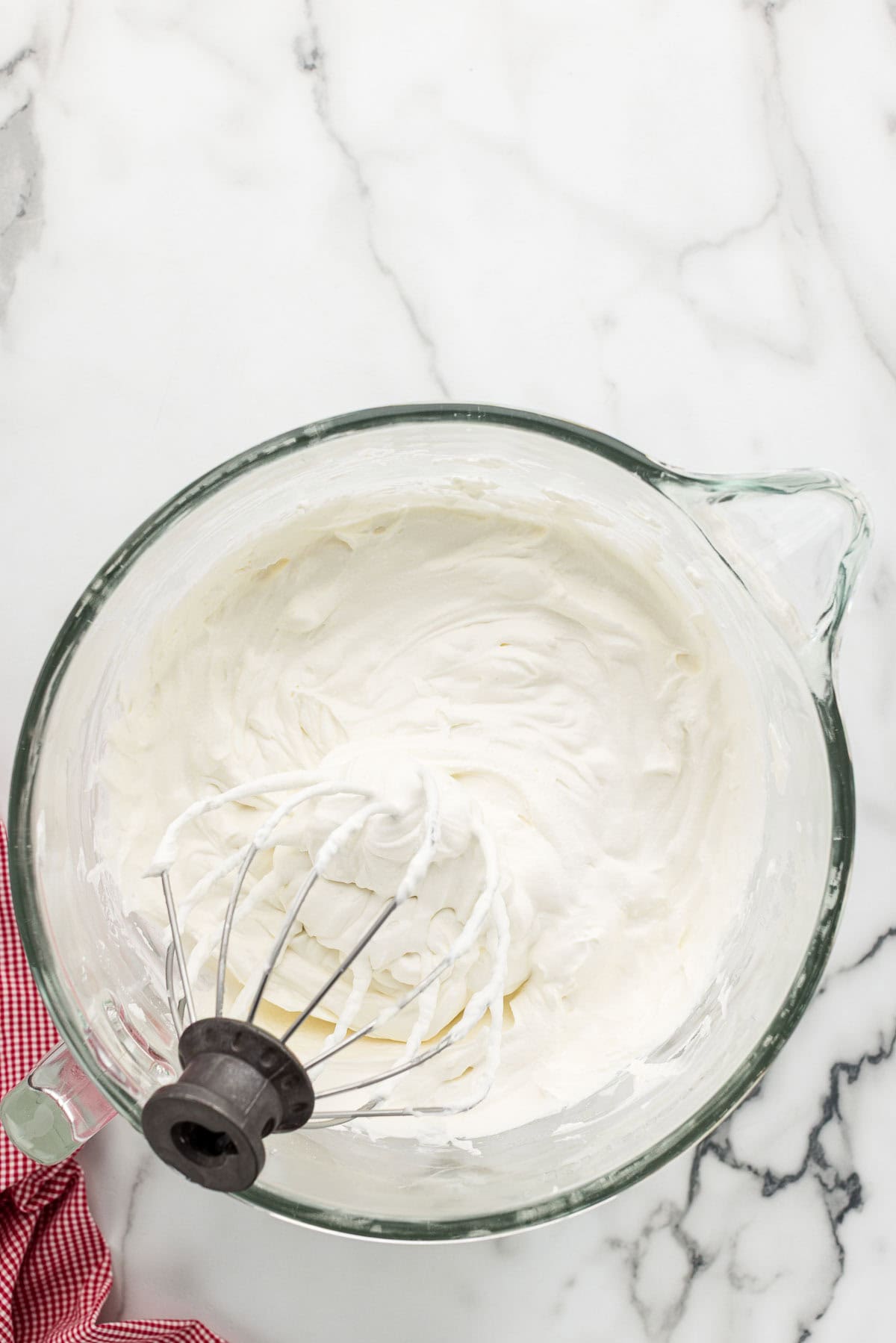 Whipped frosting in a bowl with a mixing paddle.