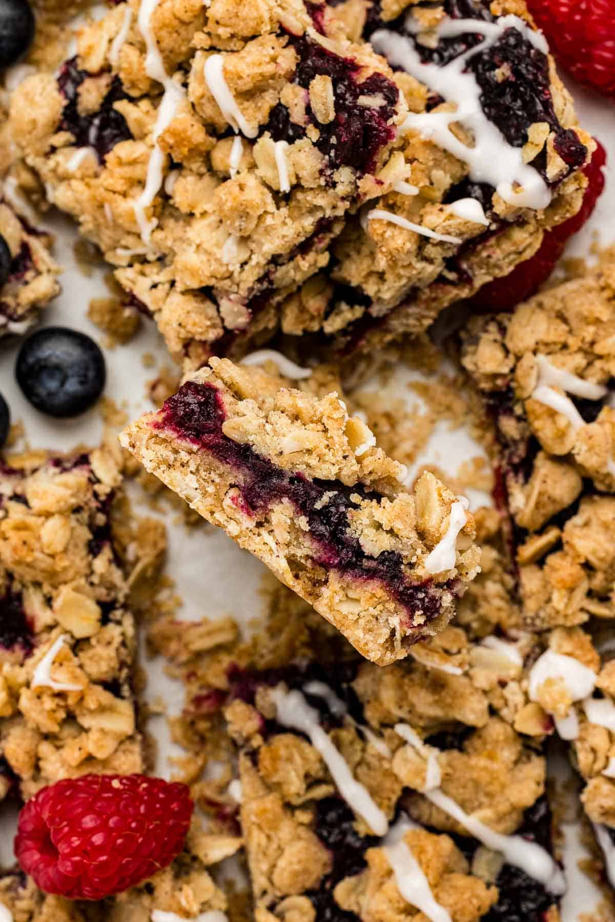 A cluster of berry crumble bars with blueberries and raspberries.