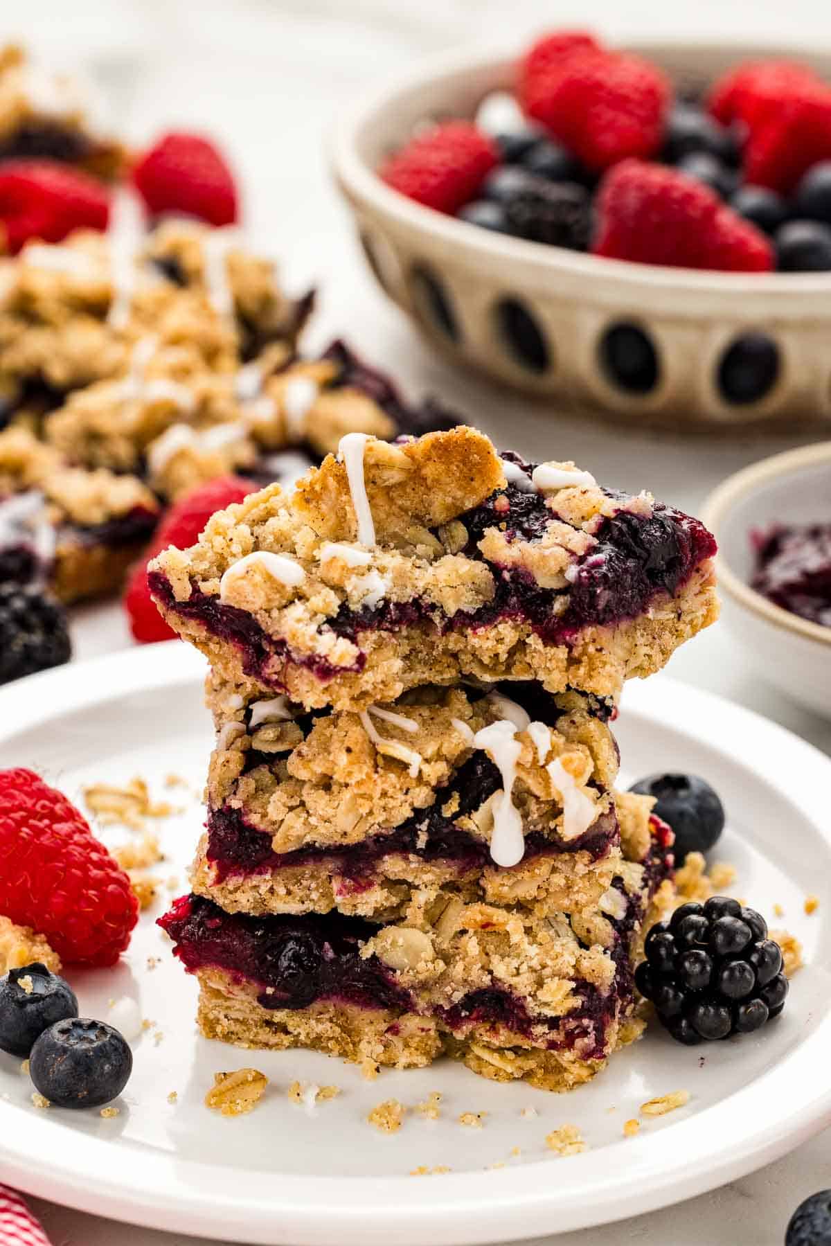 A stack of crumble berry bars on a small white plate.