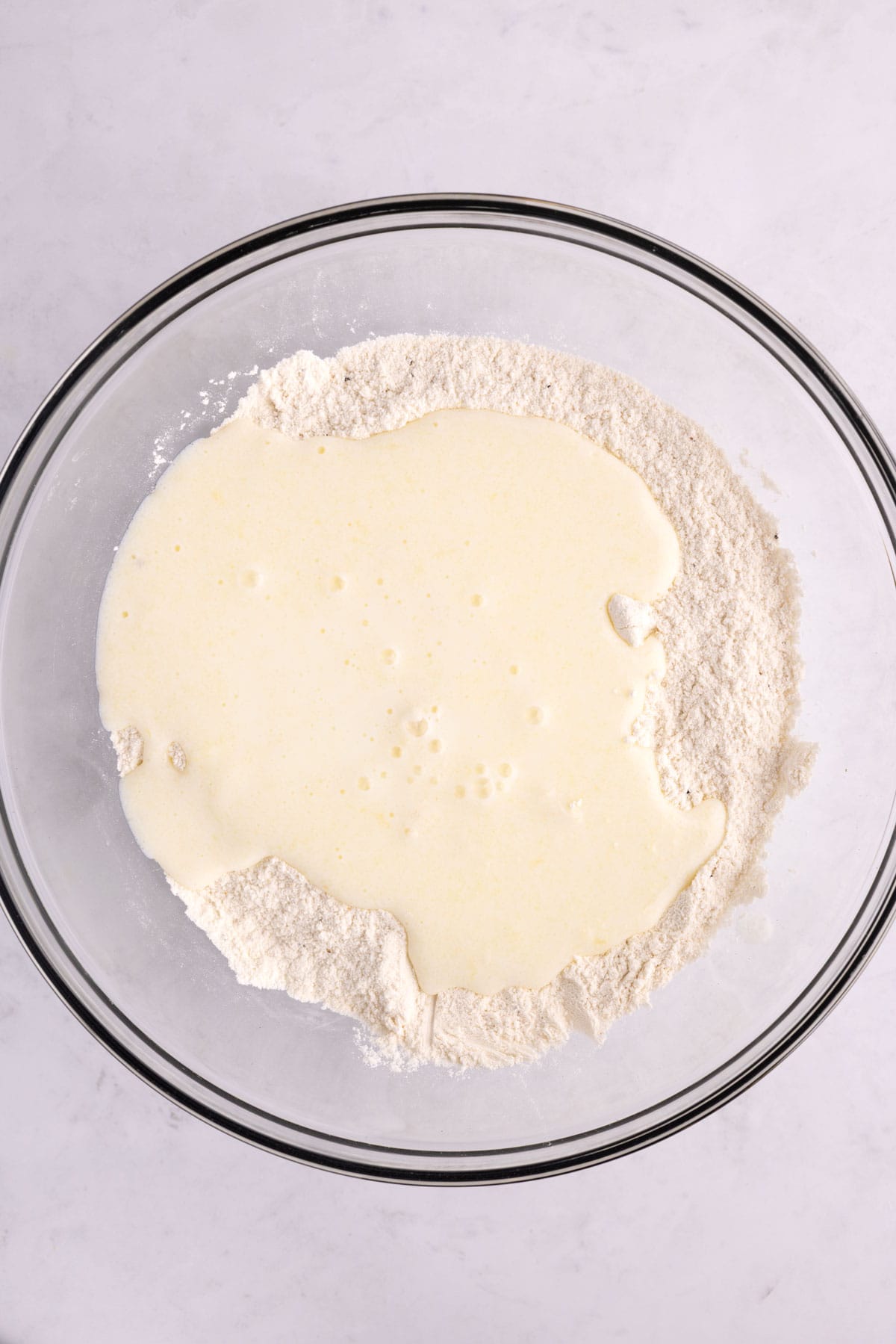 Biscuit ingredients unmixed in a glass bowl.