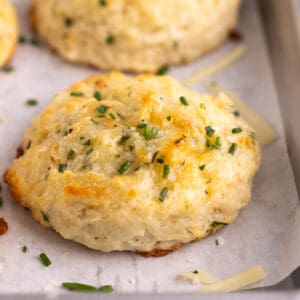 Closeup of a golden biscuit topped with chives.