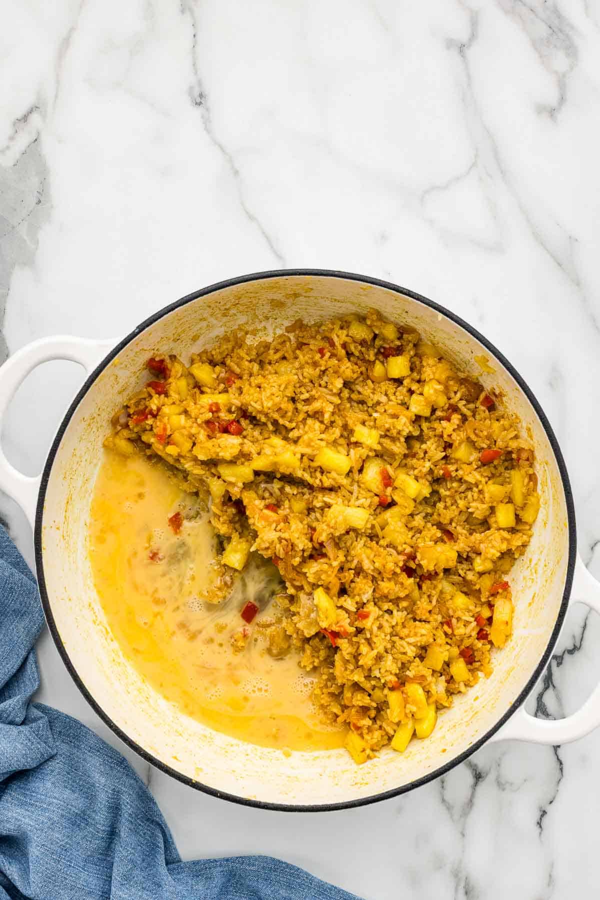 Pineapple rice mixed in a pan with eggs.